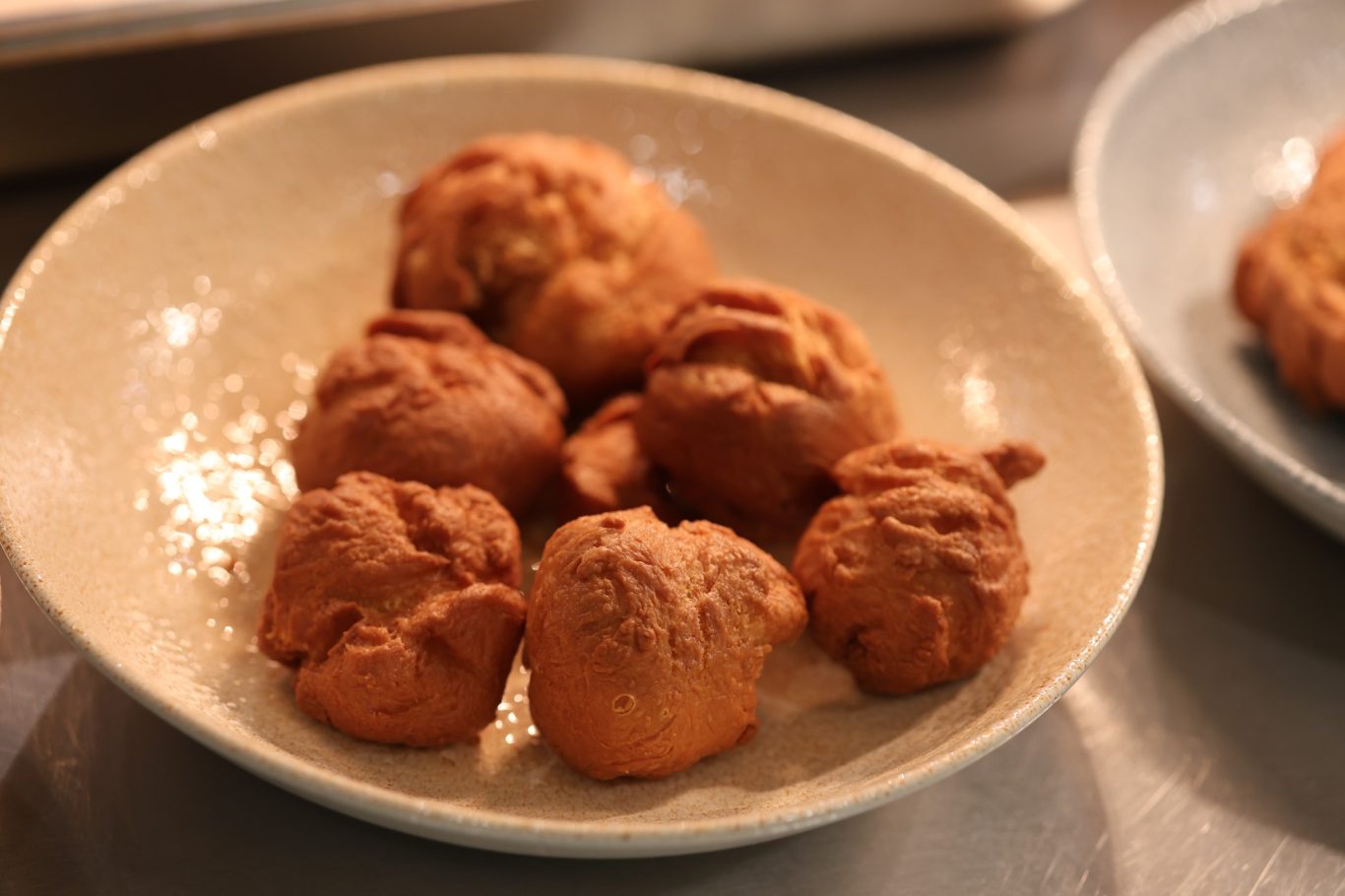 Leckere, goldbraun frittierte Bällchen auf einem Teller.