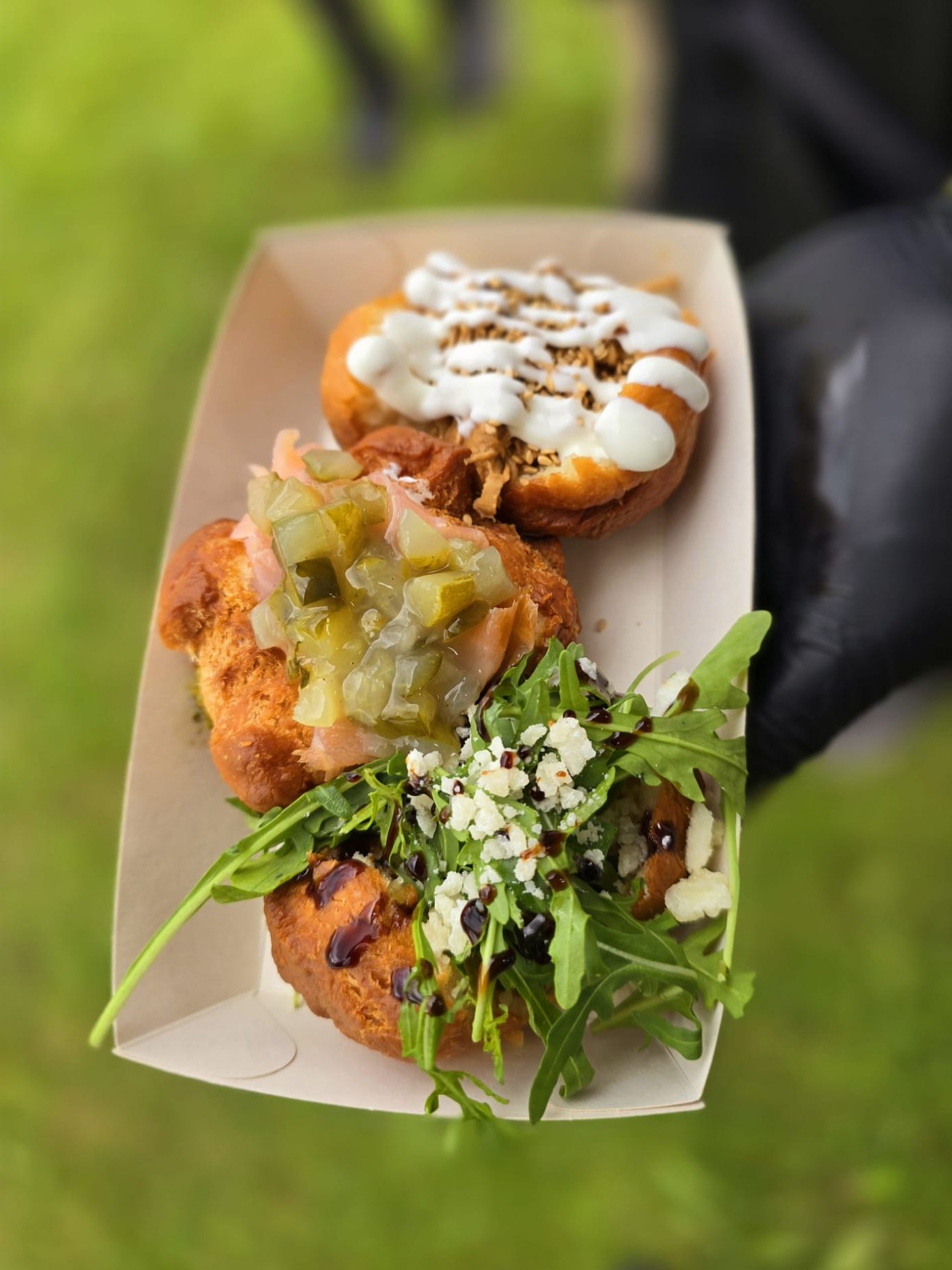 Drei verschiedene gefüllte Rickettz auf einem Papptray, bunt garniert.