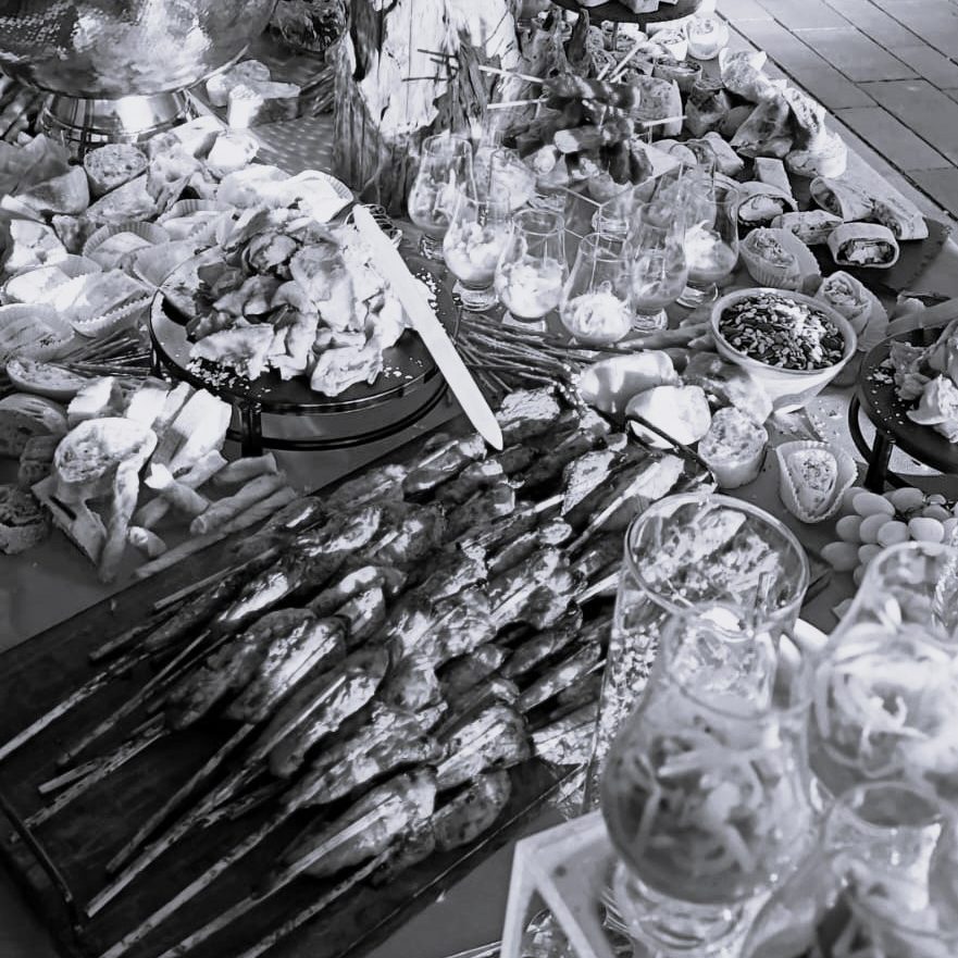 Ein reichhaltiges Buffet mit Speisen, Getränken und dekorativen Cocktails.